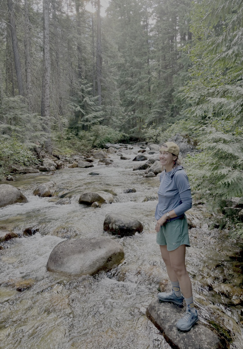 Brittnea Cordial hiking by a mountain stream